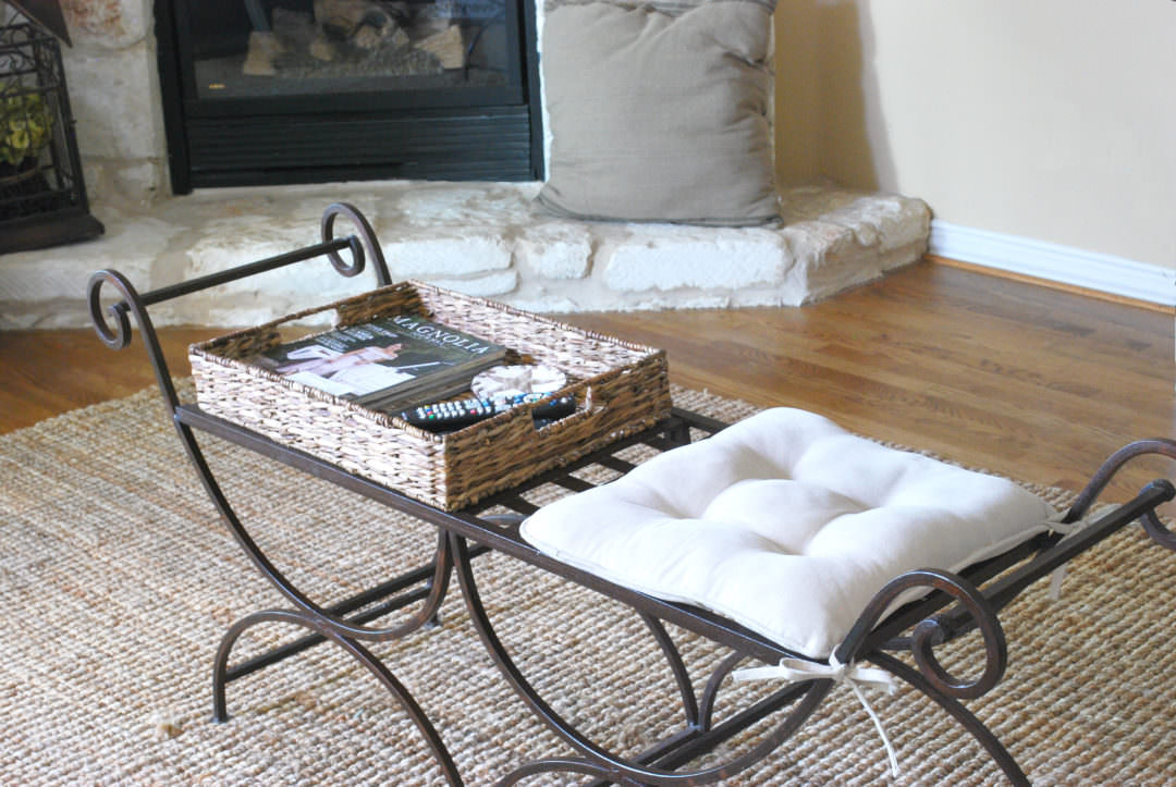 iron bench used for coffee table refresh with cushion and woven tray