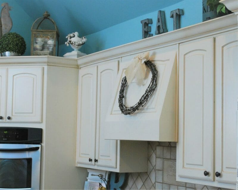 barbed wire wreath hanging above stove in farmhouse kitchen