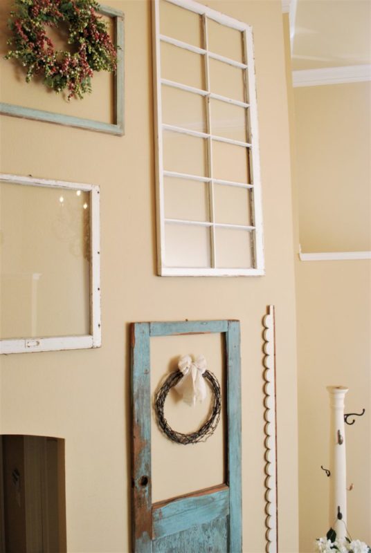 DIY barbed wire wreath haning in entry on window and door collage wall