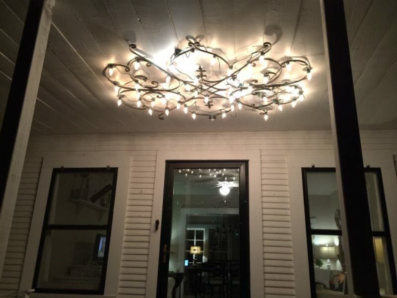 farmhouse front porch with new iron light fixture with Christmas lights