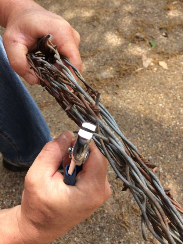 Wrapping the end pieces with pliers for a DIY barbed wire wreath