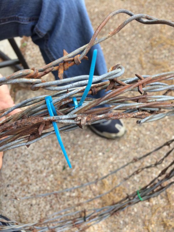 DIY barbed wire wreath using zip ties to hold it in place