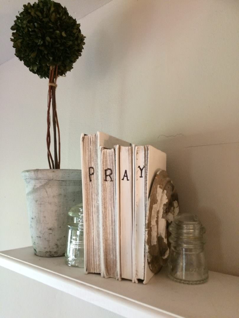 Books that were painted and had the word PRAY wtritten on them with a Sharpie pen for farmhouse decor