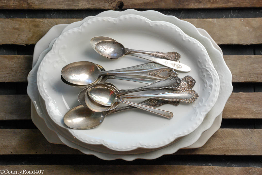 Collection of white dishes and silverware by countyroad407.com
