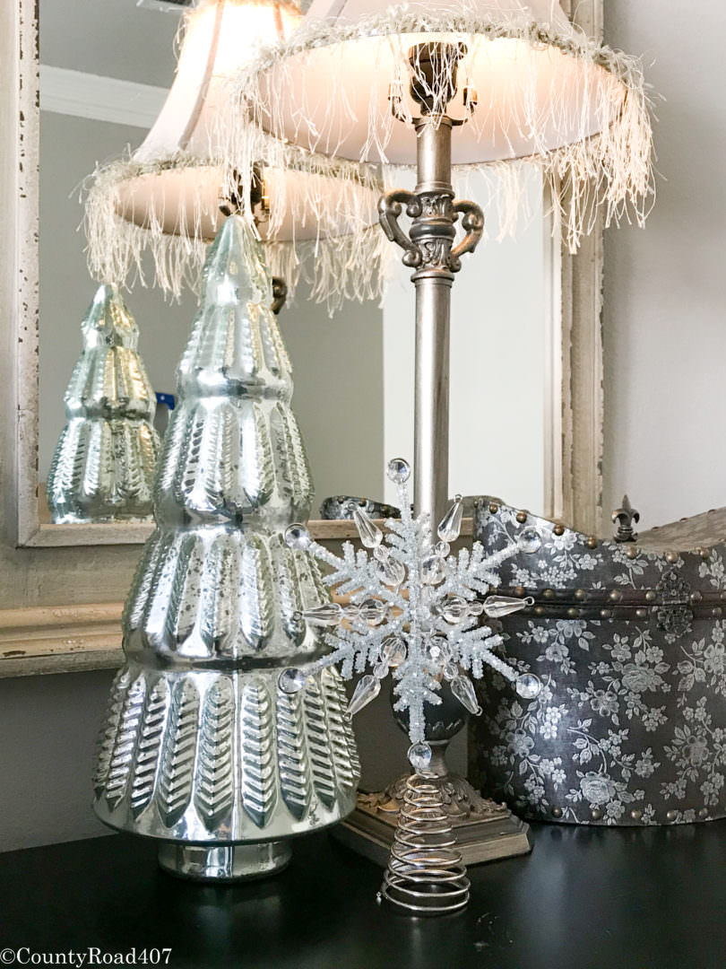 Glass trees and a tree topper make inexpensive bed side table Christmas decor. Countyroad407.com