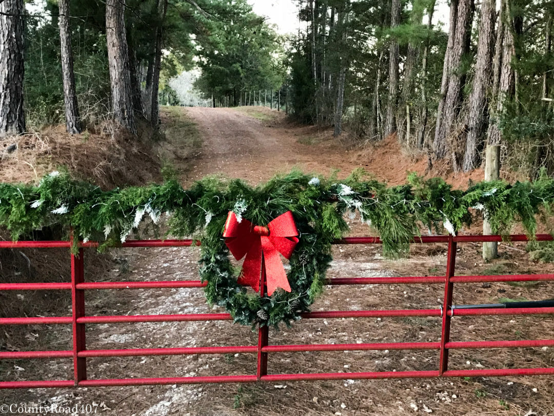 Fresh garland wreath on red front farm gate