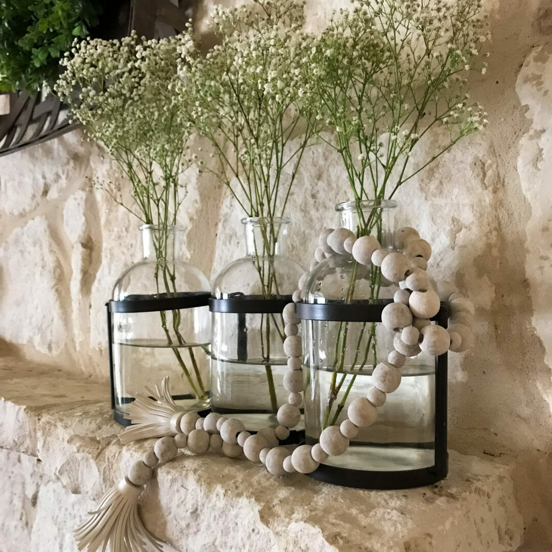 Glas vases with wood beads and baby's breath for a spring mantel pick-me-up. CountyRoad407.com