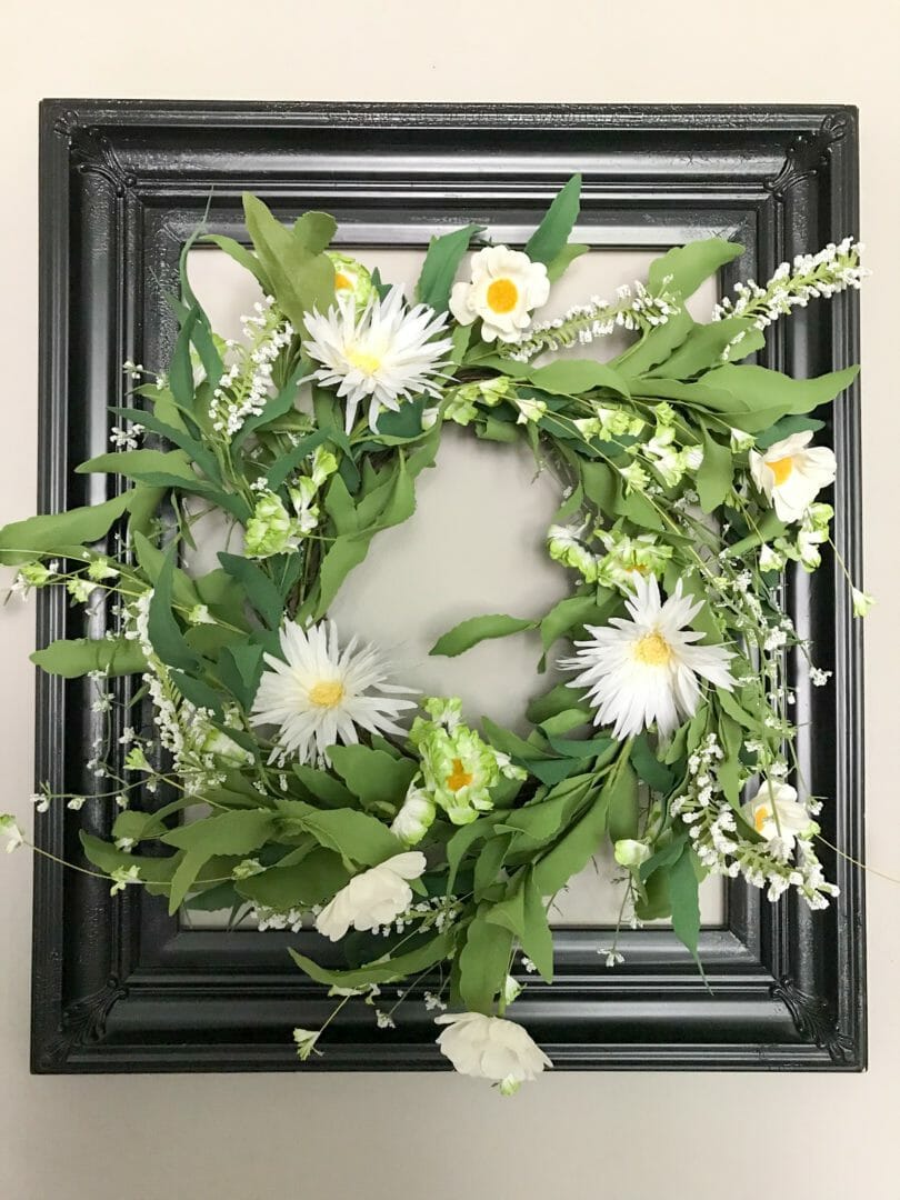 black frame with spring wreath inside