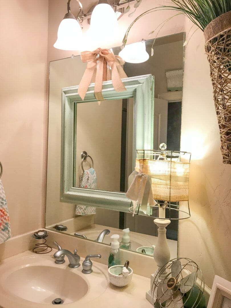 Hang an empty mirror over those ugly builder grade mirrors for a fun update! How I use empty frames in my decor by CountyRoad407.com