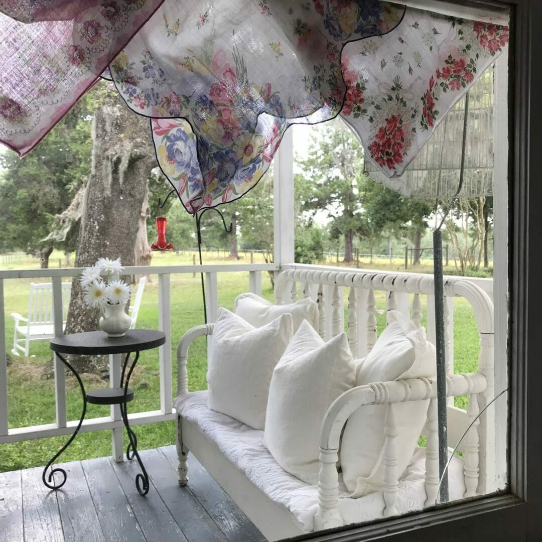 baby bench bench on porch with handkerchief window valance and side tale with flowers