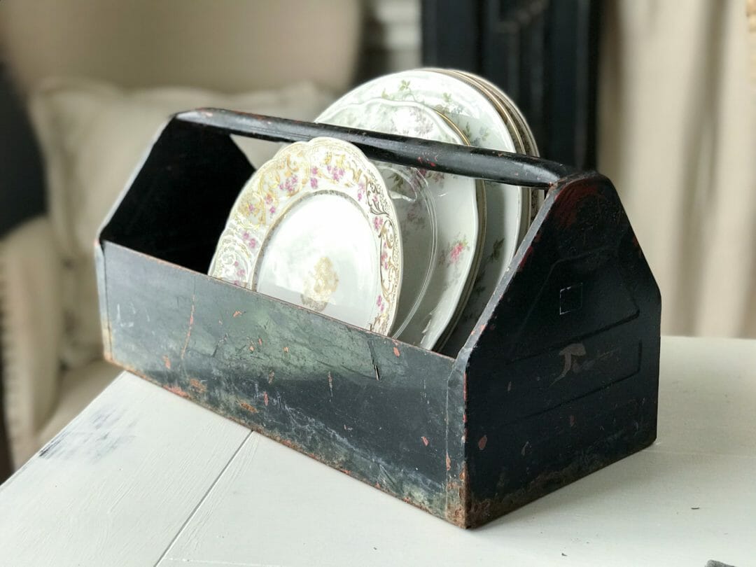 Antique plates displayed in a vintage toolbox by CountyRoad407.com