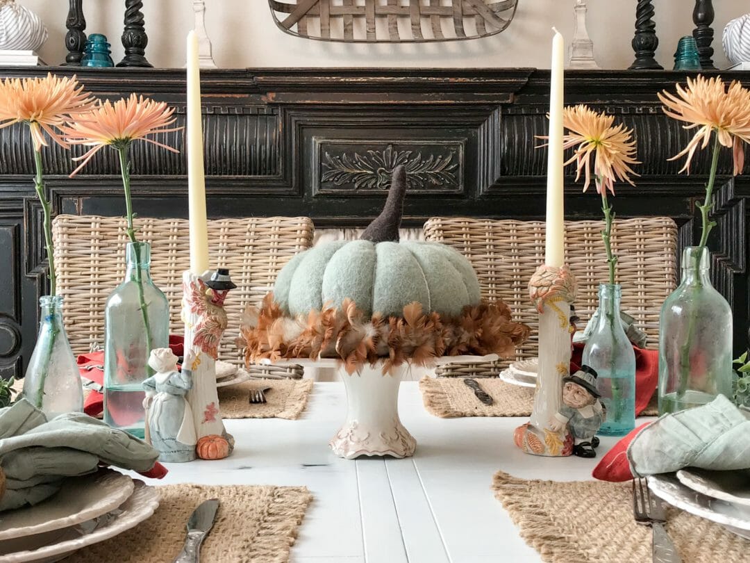 blue felt pumpkin on a cake plate with funny thanksgiving candlesticks