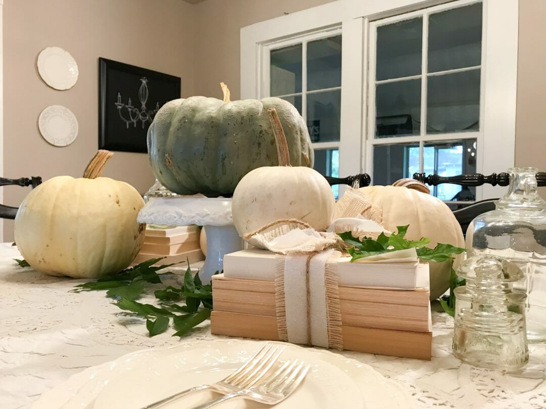 A neutral fall tablescape by using old deconstructed books and pumpkins by CountyRoad407.com