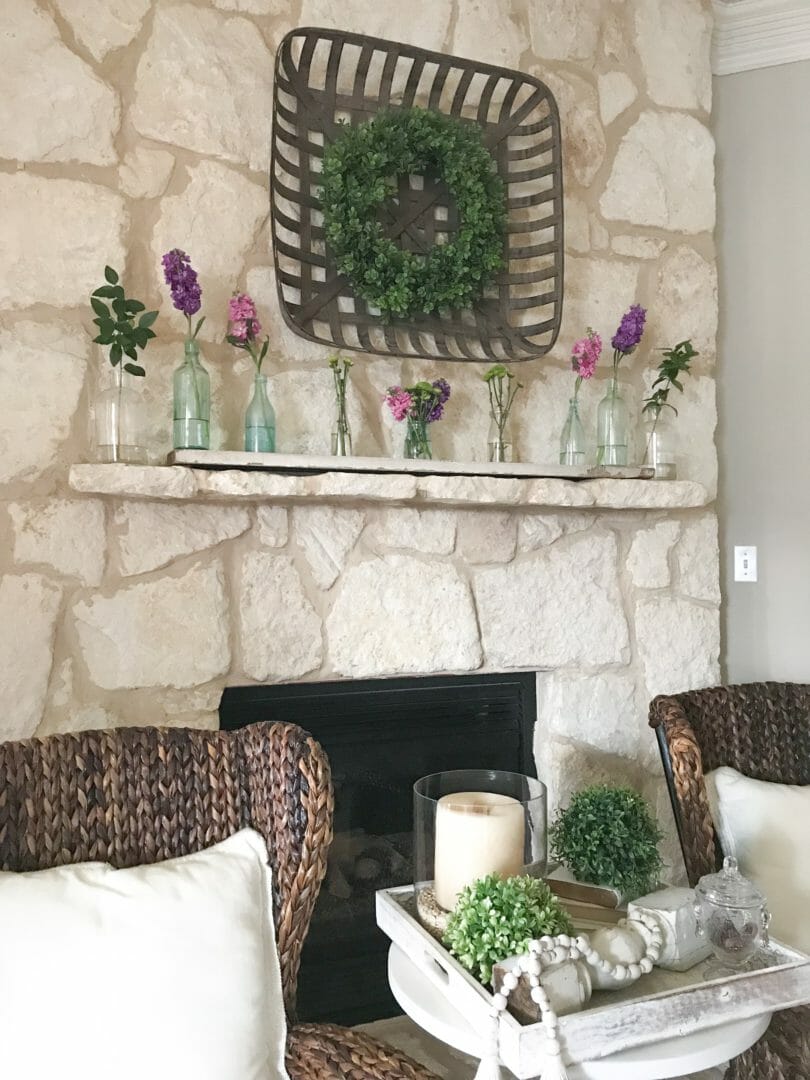 Spring mantel using vintage bottles by CountyRoad407.com #springmantel #springmantle #Springdecor #springdecorating #spring #decor #manteldecor #mantledecor #vintagebottles #bluebottles