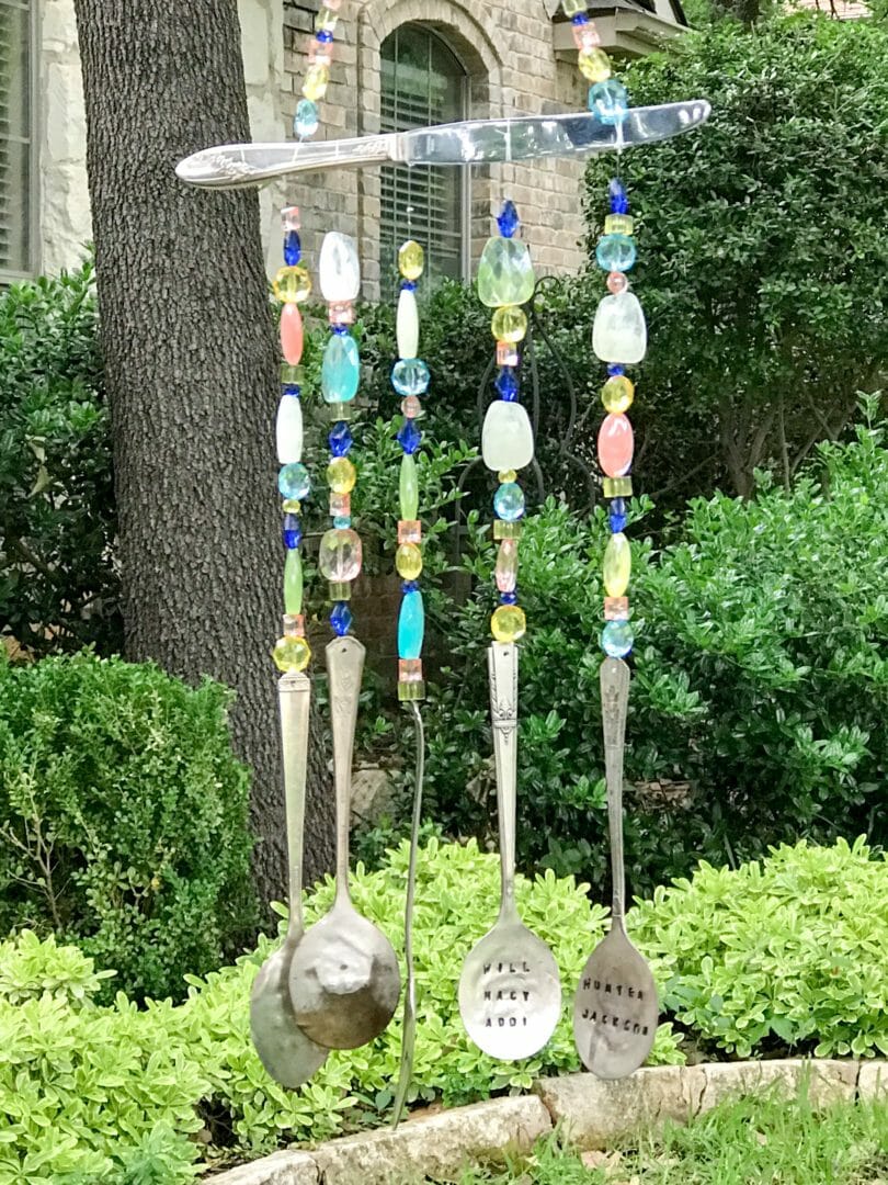 Stamped Spoon Wind Chime with blue and peach beads hanging from a silver knife