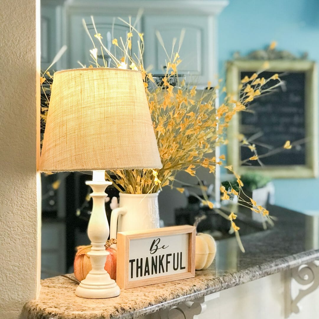 lamp on bar with flowers and a sign and a chalkboard