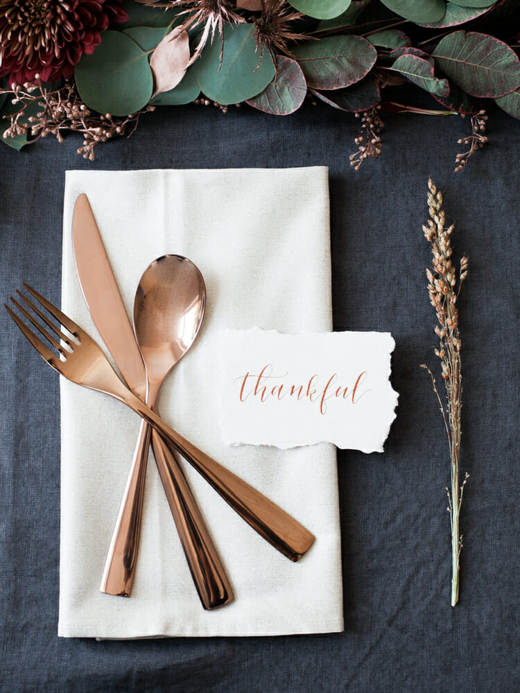 placesetting with copper flatware and thankful tag
