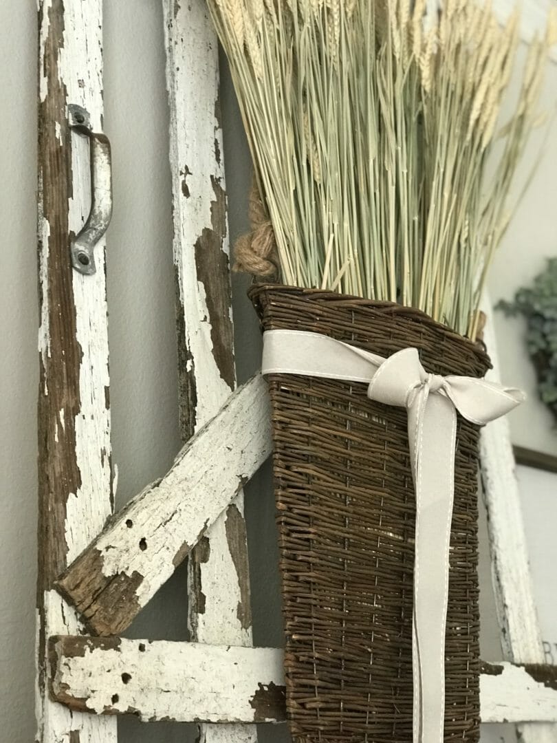 old fence gate with basket of wheat hanging on it