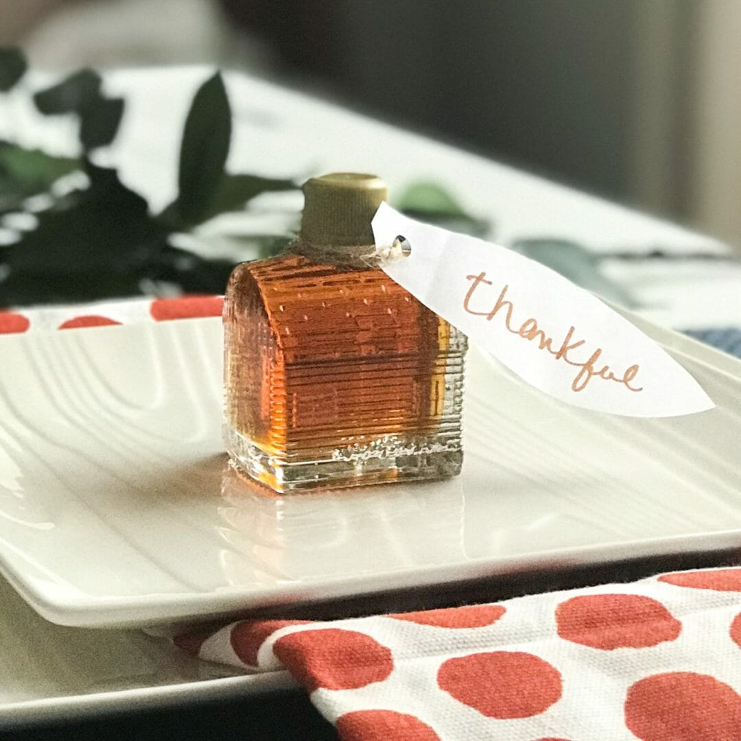 white plate with glass cabin of syrup and thankful tag