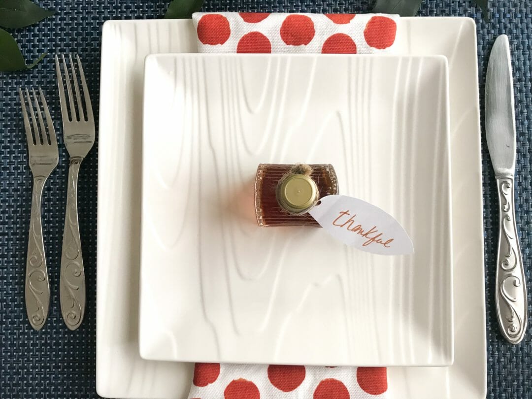 white dish place setting with copper polka dot napkin