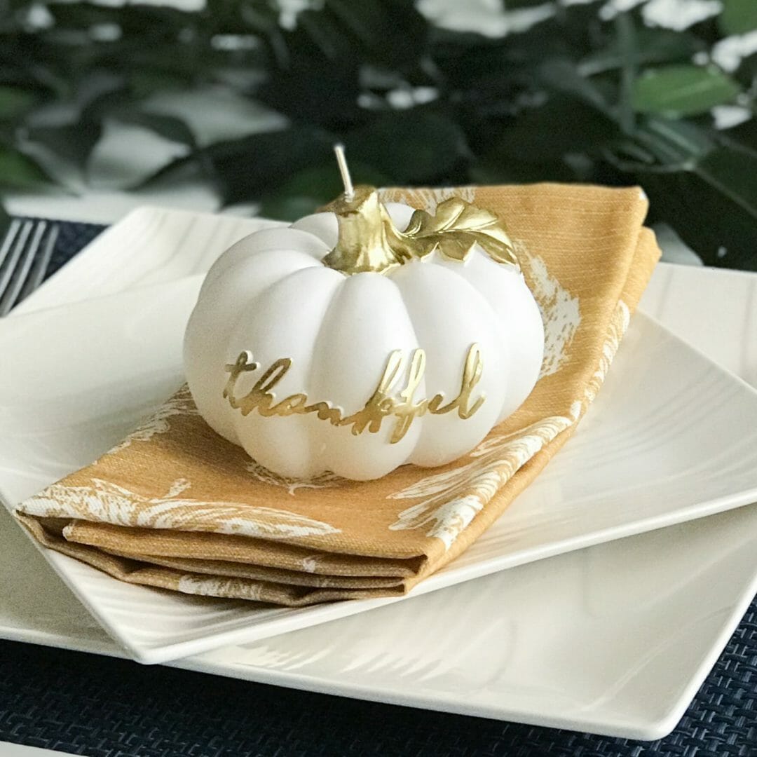 white plates with gold napkin and white pumpkin