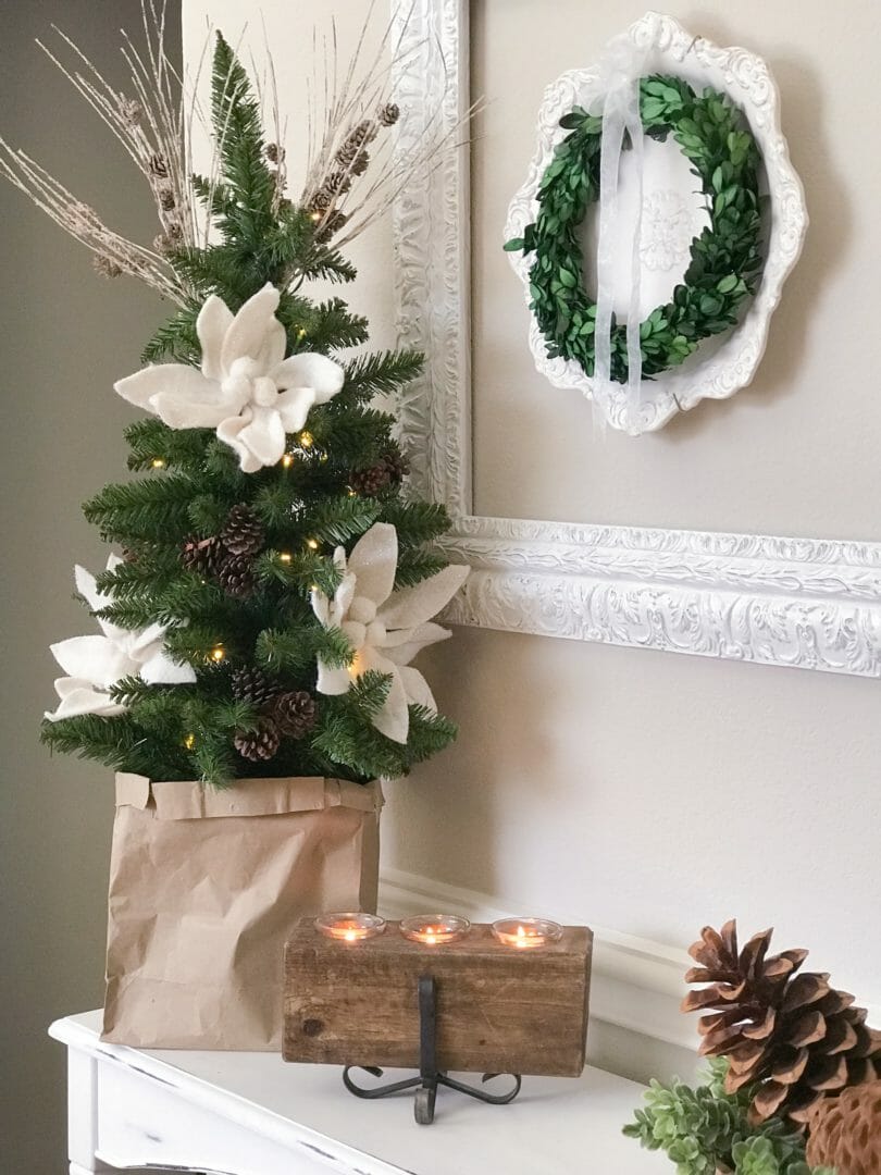 Christmas tree in bag with candle and framed plate and wreath