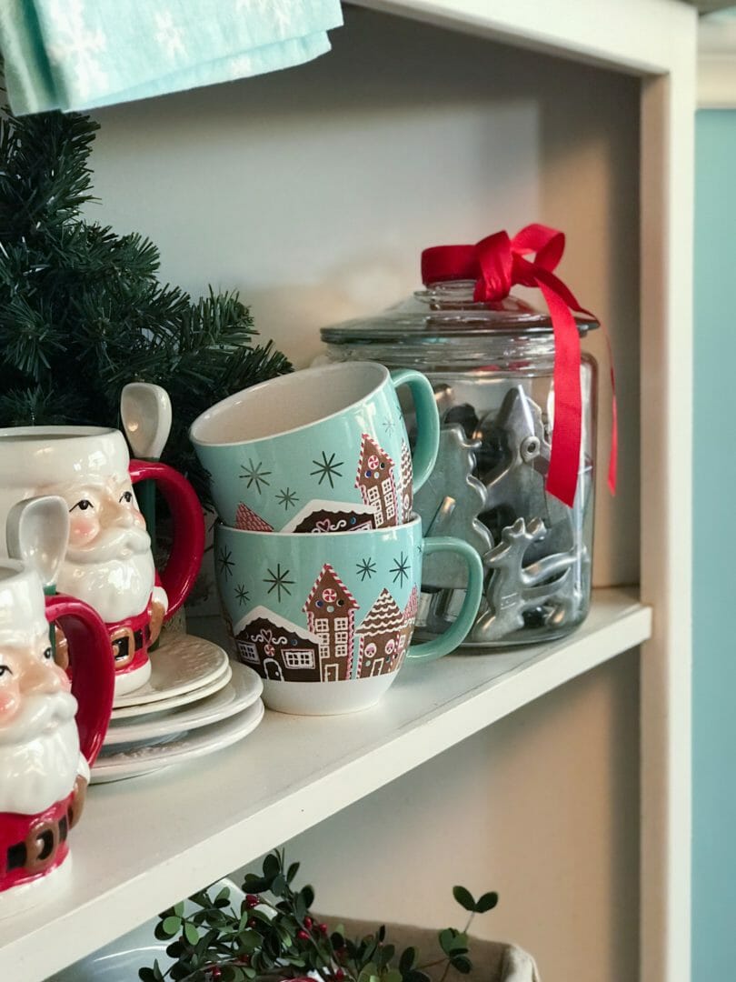 christmas cups on shelf with cookie cutter jar