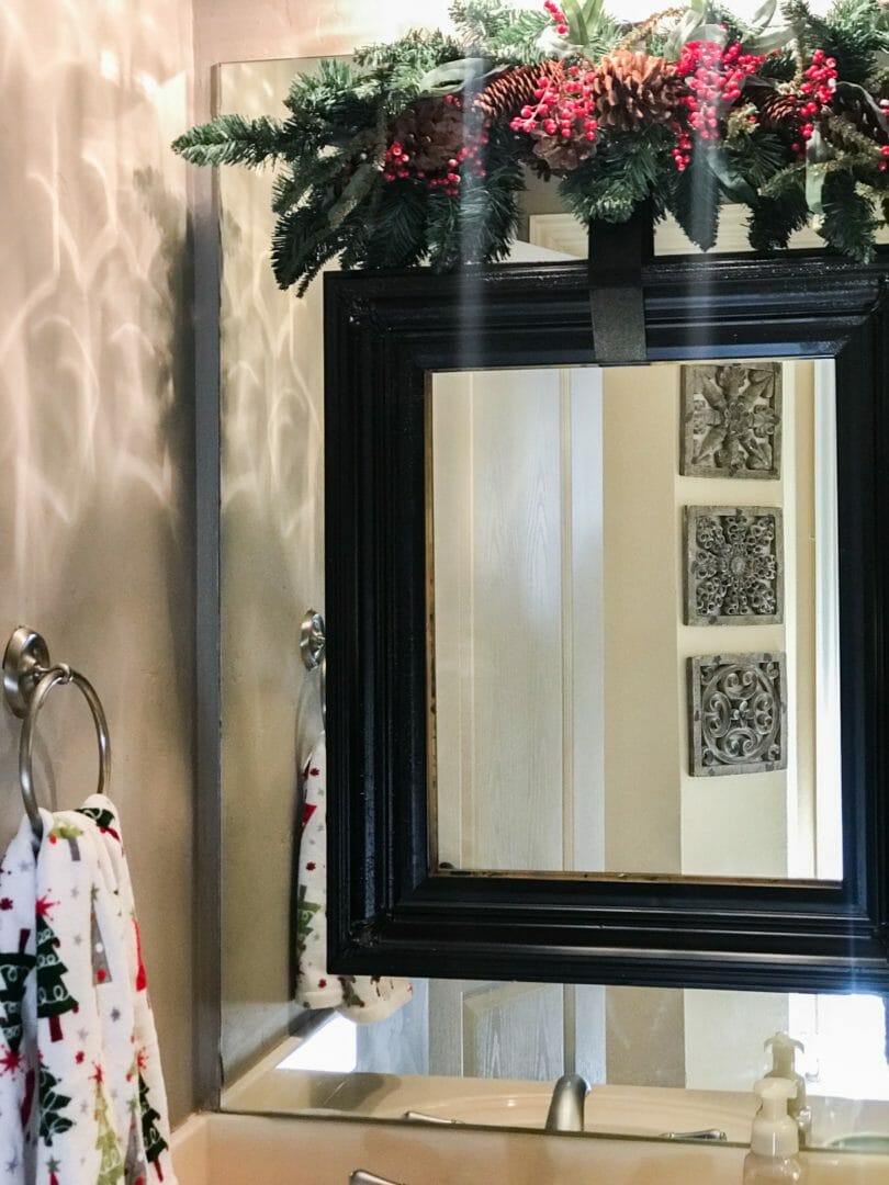 frame on a birror with Christmas towel and swag