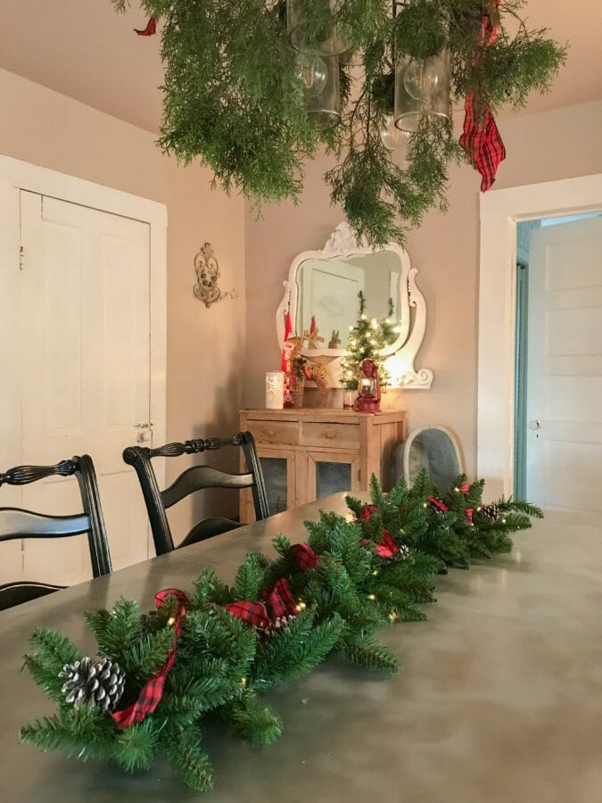 garland on table with greenery on chandelier