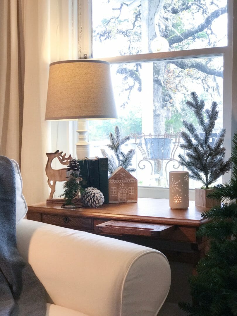 antique table in front of window with Christmas decor
