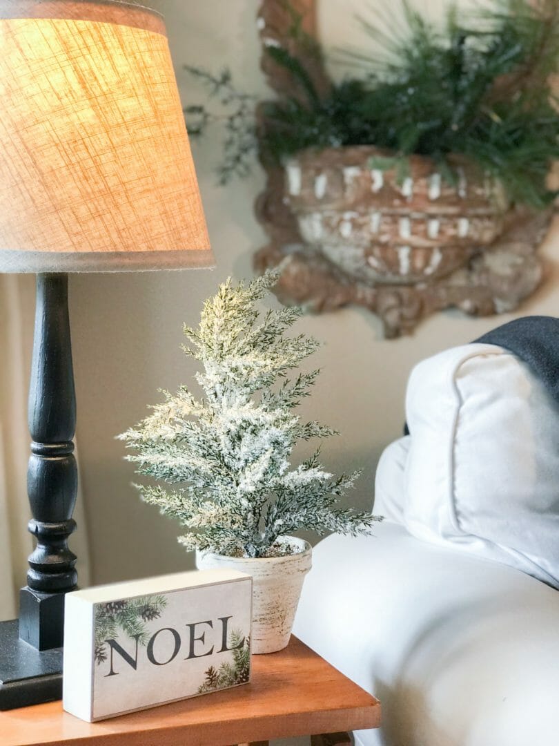 chair with Noel sign and small tree and lamp