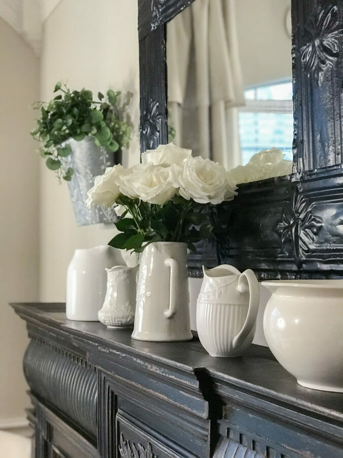 mantel with white pitchers and flowers