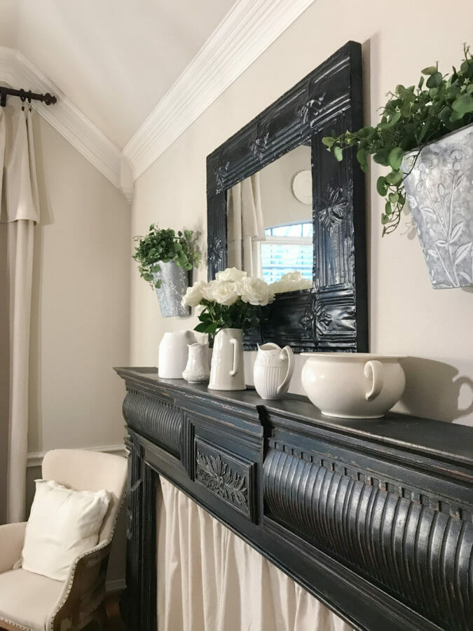 black mantel side view with white pitchers and greenery
