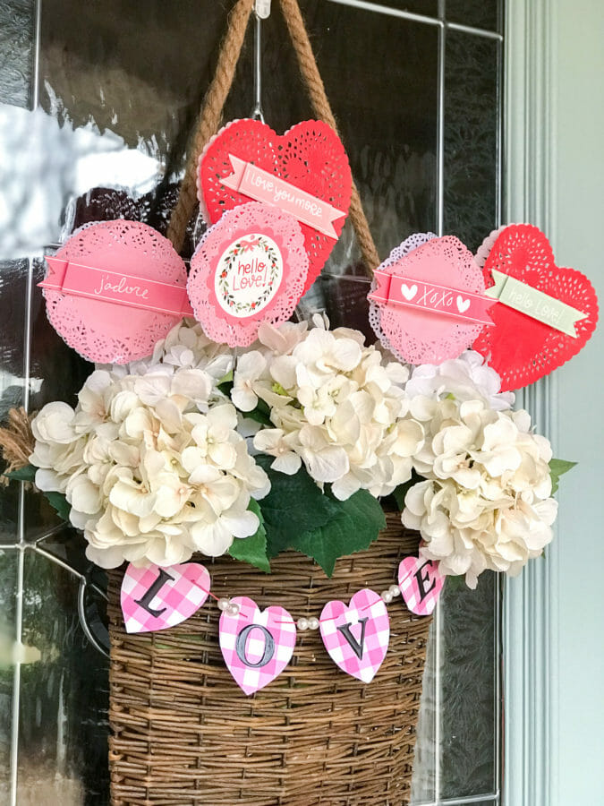 hanging basket on door with white flowers, LOVE garland and heart picks