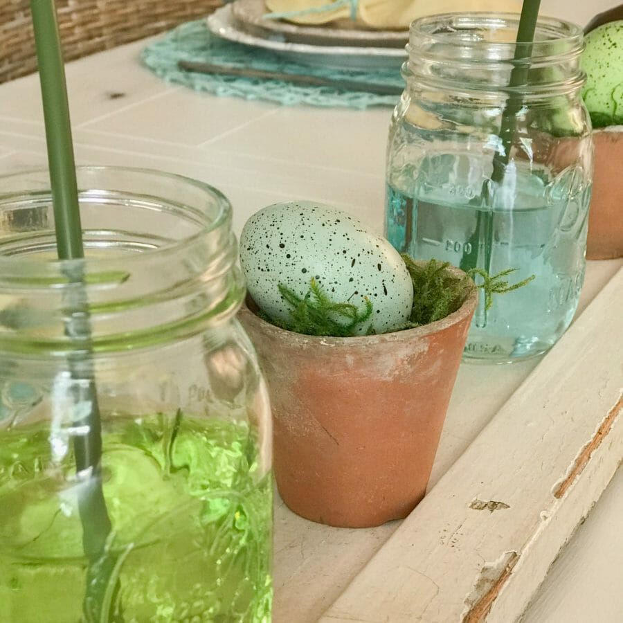 close up of mason jars with colored water and clay pots