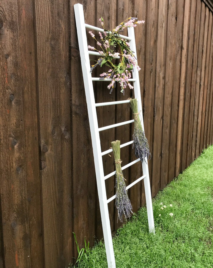 baby bed rail with flowers leaning on wooden fence