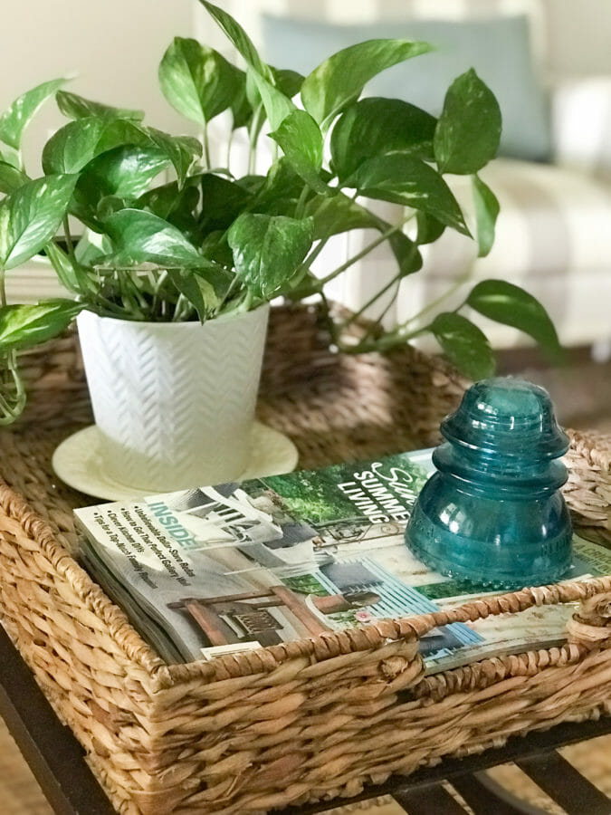 straw basket with plant, magazines and vintage insulator