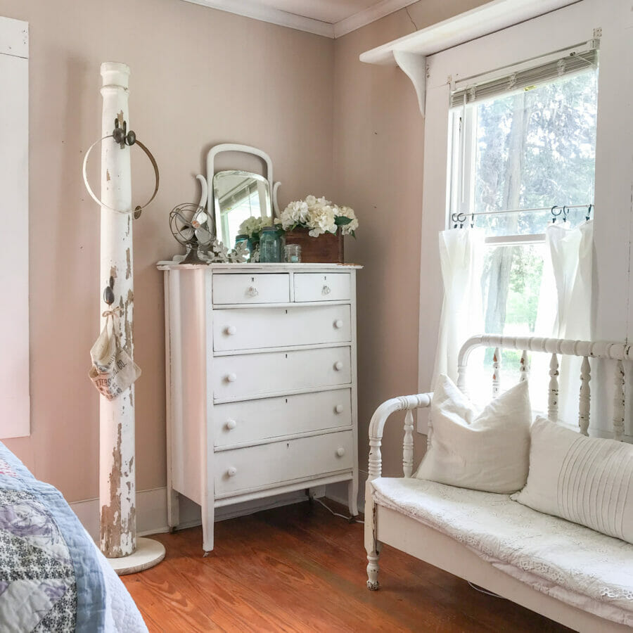 vintage chest of drawers, column and bench in front of window