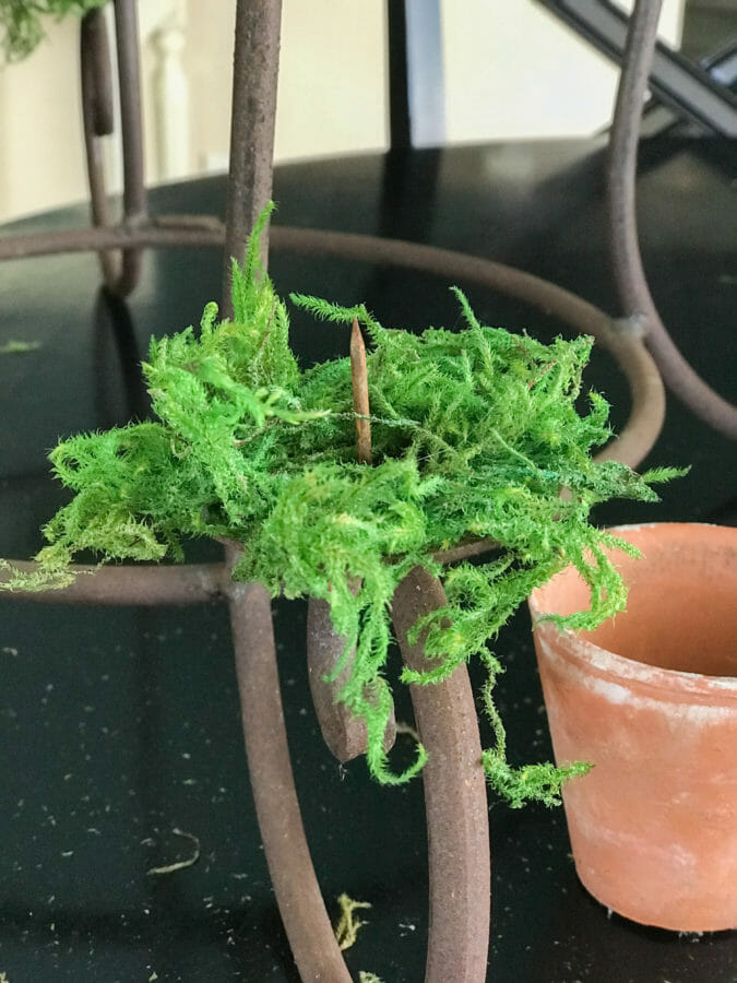 moss hot glued onto stem of candelabra