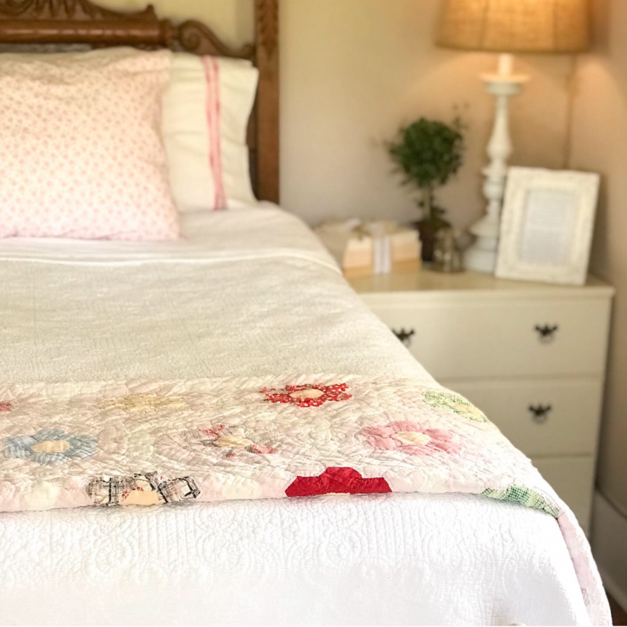 antique bed with pink quilt and side table