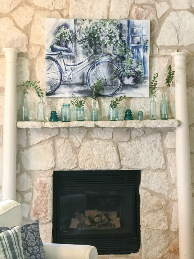 summer mantel with artwork, vintage bottles and columns