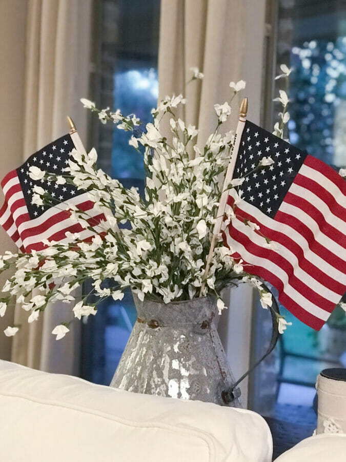 watering can with white flowers and flags