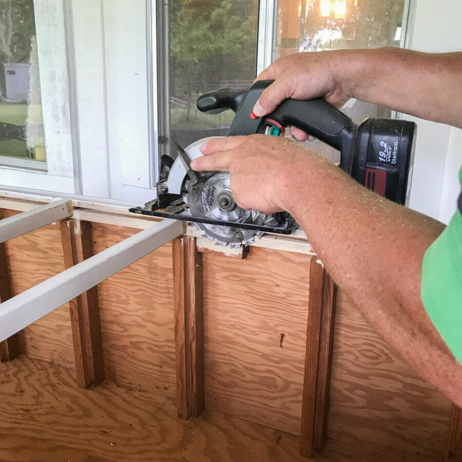 sawing off wood piece on chest of drawers