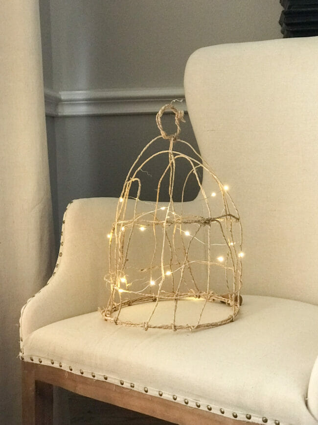 grapevine wire cloche with fairy lights sitting in chair