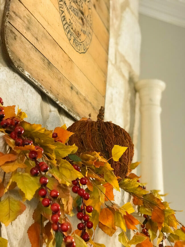 fall mantel with pumpkin and fall leaves and berries