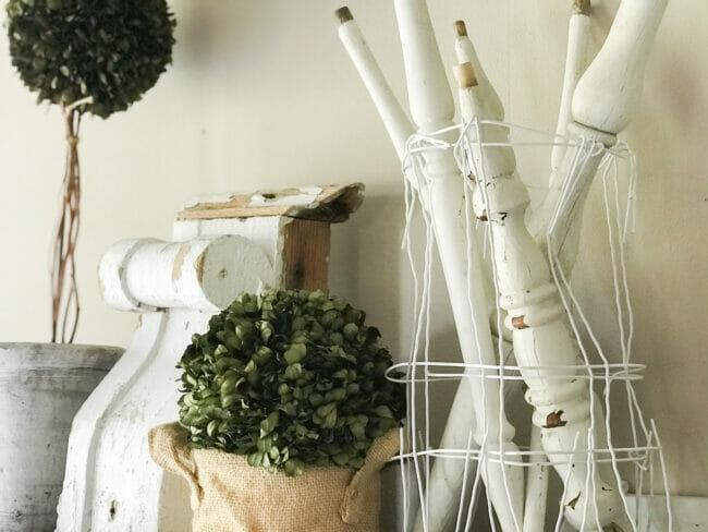 vintage spindles, boxwood greenery and white chippy architectural piece