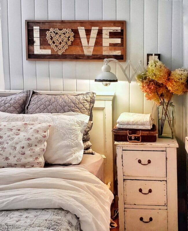 bed with side table and LOVE art work over bed