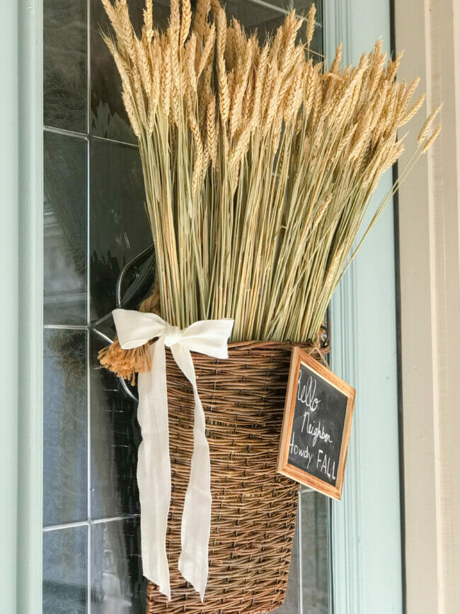 willow basket with wheat, bow and fall chalkboard sign