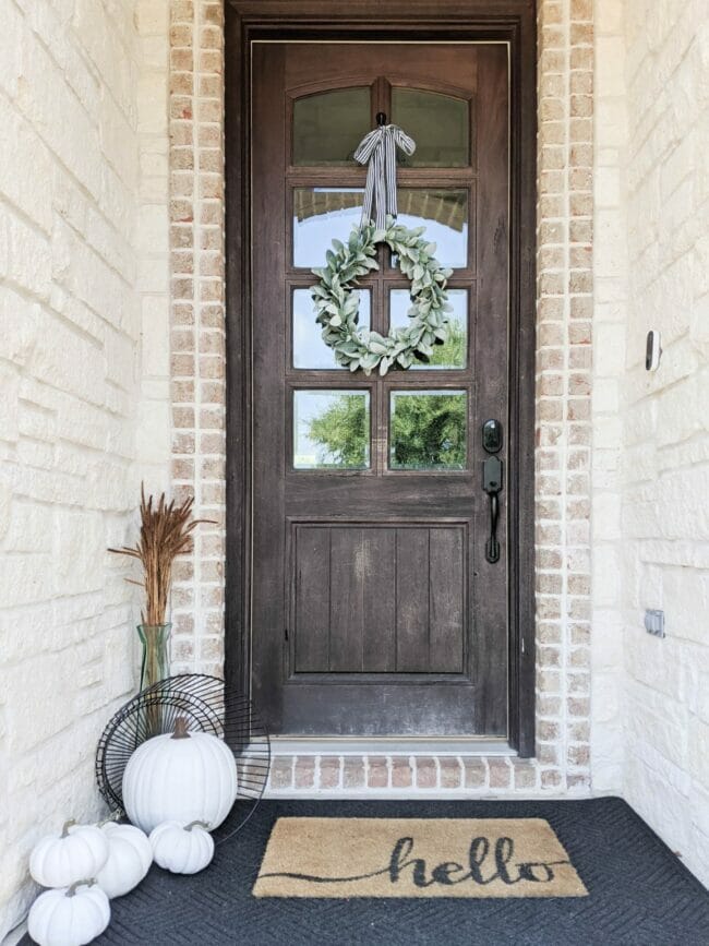 rustic front door with white pumpkins and wreath