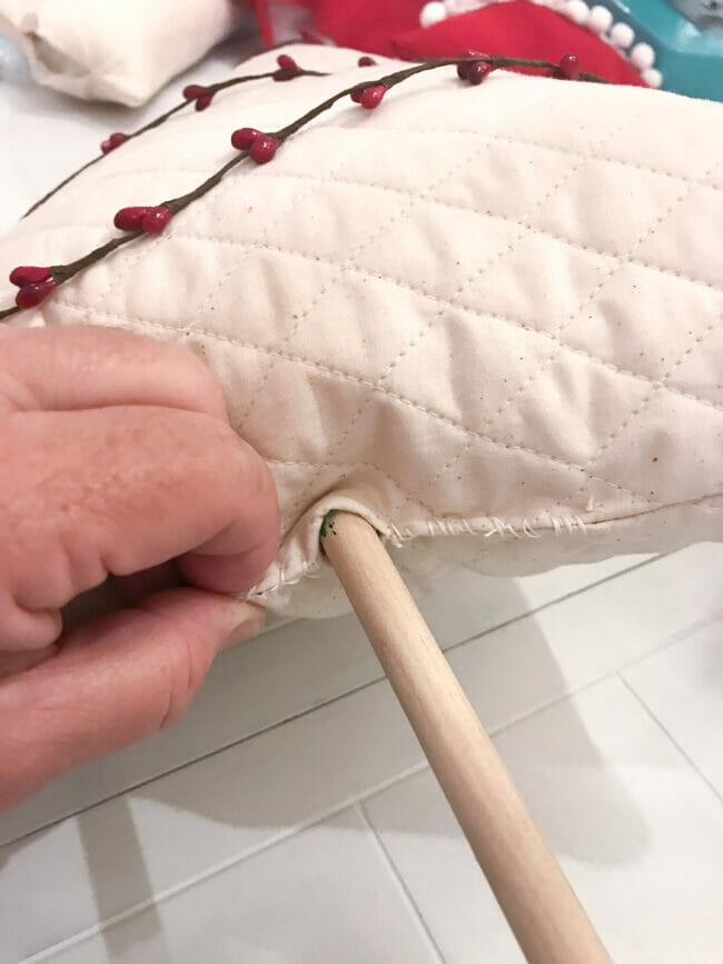 sticking dowel rod into bottom of decorated fabric Christmas tree